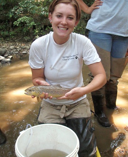 Image of a monitoring intern holding a fish.
