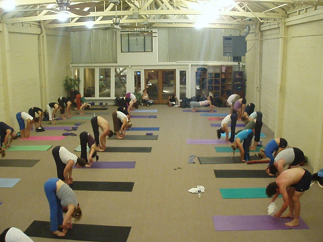 Class grabs big toes during a Forward Fold pose