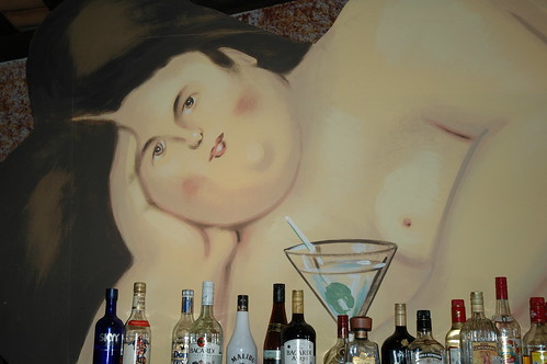 Portrait of a nude over the bar, that faraway look in her brown eyes, bottles of alcohol, cocktail, Puerto Vallarta, Mexico by Wonderlane