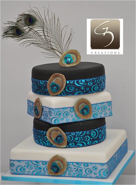 The top of the cake showcases real peacock feathers