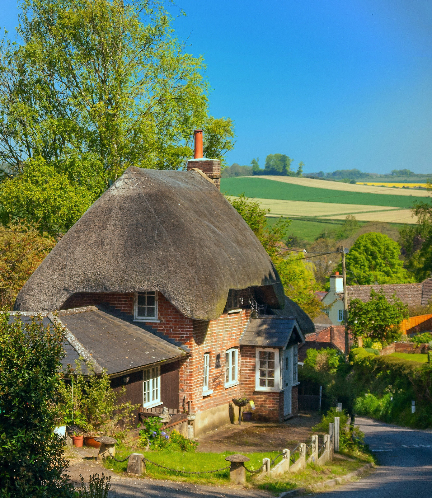 A pretty thatched cottage above the village of Pitton in Wiltshire. Credit Anguskirk