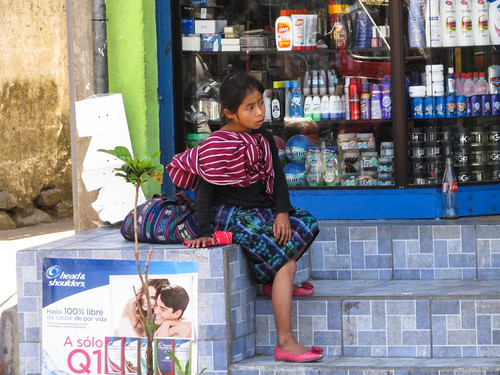 Panajachel: une petite fille en habit traditionnel. Mais que cache-t-elle derrière son dos?