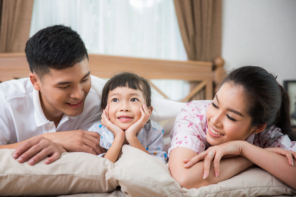 Asian family on a bed, father