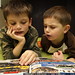 brothers poring over a lego catalog that arrived in today's mail