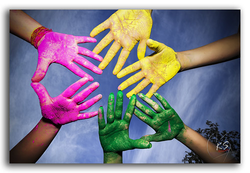 Colorful hands of teenagers celebrating Holi!