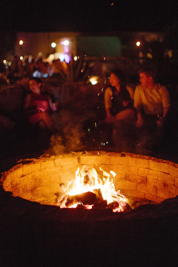 Outdoor seating area with fire pit lit up by festoon lights | Rustic romance Wedding in Texas