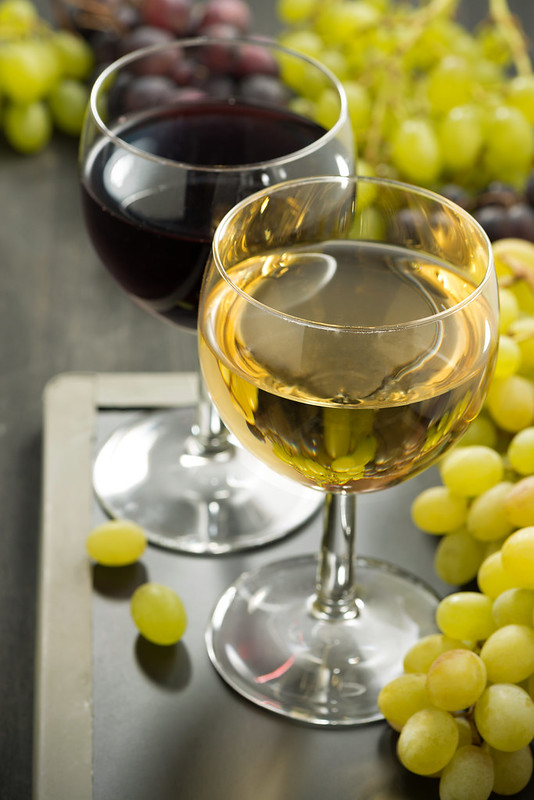 glasses of white and red wine and grapes