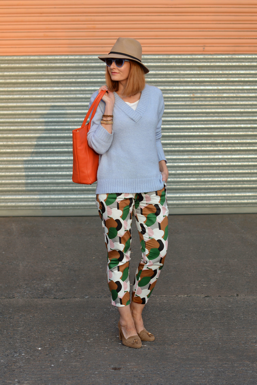 Spring style: Bold patterned pants, pale knit, orange tote, camel fedora | Not Dressed As Lamb