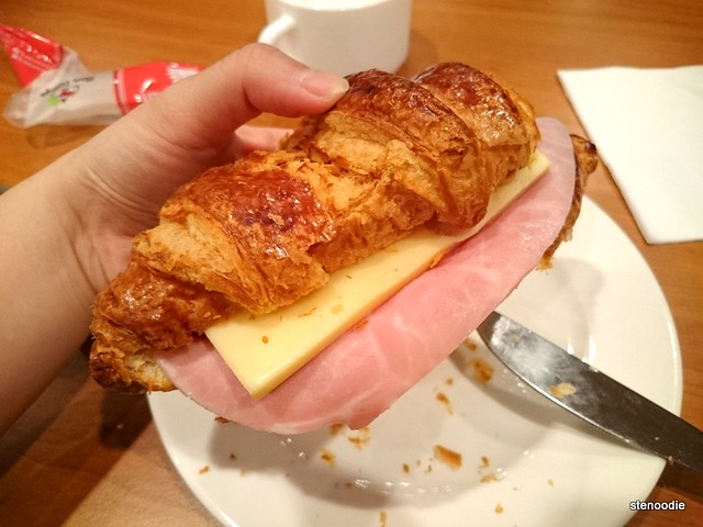  Hand holding ham and cheese croissant