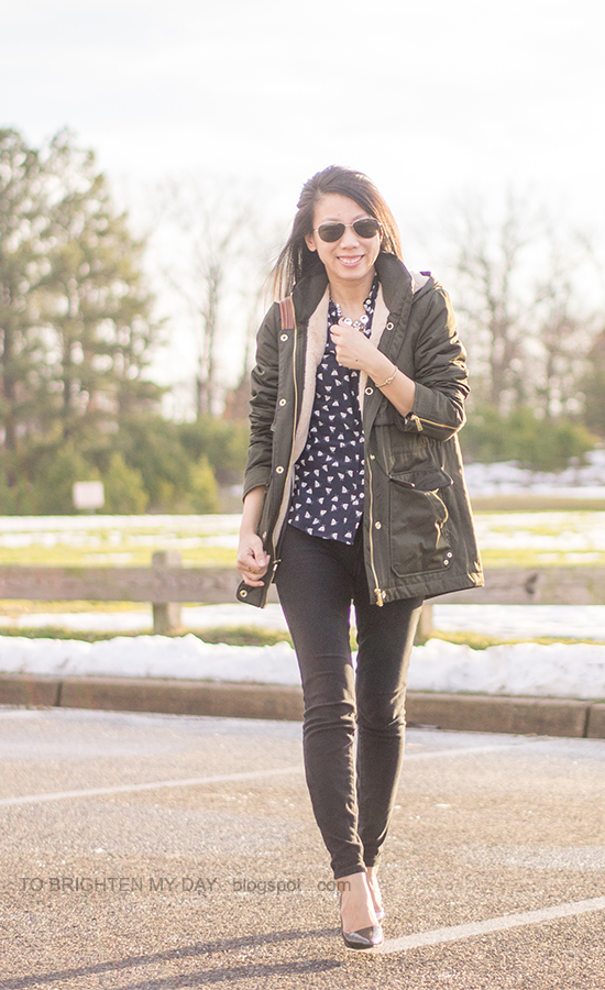 olive green coat, navy printed silk blouse, black jeans, gold jewelry, black patent pumps