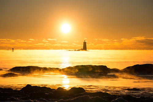 ocean winter light sky lighthouse cold water sunrise maine newengland newhampshire nh coastline atlanticocean seasmoke whalebacklight robertallanclifford robertallancliffordcom