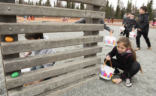 Emilee Wilson, 10, stoops down to grab an egg while participating with other kids in the older children's egg hunt.