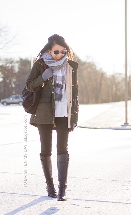 plaid oversized blanket scarf, military green parka, ruffled gray sweater, gray gloves, black riding boots