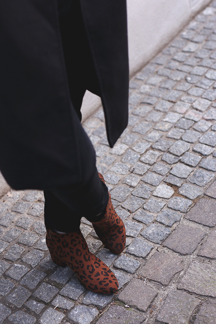 All black with leopard print boots and oversized coat