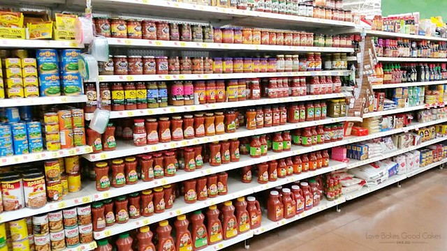 A grocery store isle with salsa products on the shelf.