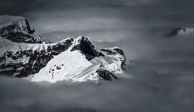 Snowy mountain peak above the clouds