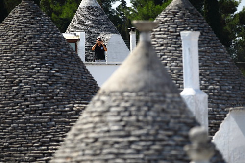 camera travel roof summer vacation people italy house man color colour building tree travelling tourism horizontal stone architecture canon outdoors person photography one town photo dof cone terrace traditional august tourist unesco worldheritagesite depthoffield shooting shape trulli salento puglia bari pinnacle conical trullo whitewashed alberobello stonehut apulia 2015 pinnacolo foregroundblur 5dmkii focusinbackground