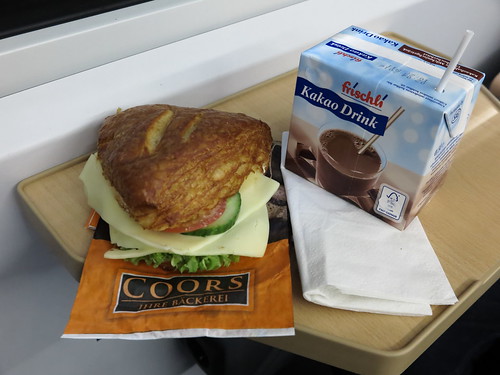 Vegetarisch belegte Laugenecke von der Bäckerei Coors (Osnabrück Hbf) mit Kakao Drink als Frühstück im Zug