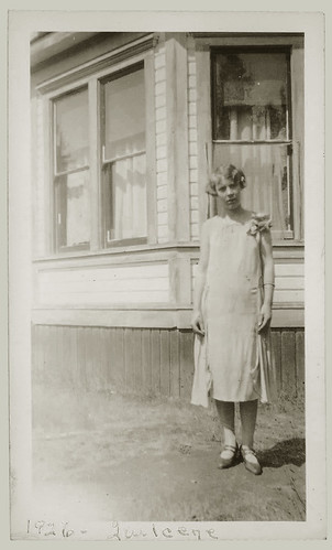 Woman standing at the corner of a house