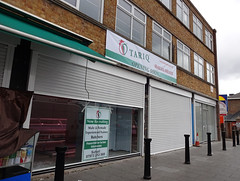 The ground floor of a building with shutters and a sign reading “Tariq Halal Meats / Opening Soon”.