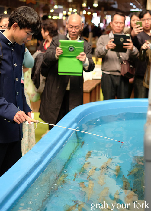 Paparazzi capturing the squid fishing game at Hakodate Morning Market, Japan