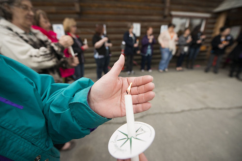 A participant in a candlelight vigil to remember victims of sexual assault shields her tiny flame from the wind outside Tyotkas Elder Center in Old Town Kenai. After a long moment of silence, participants took turns honoring family, friends and themselves