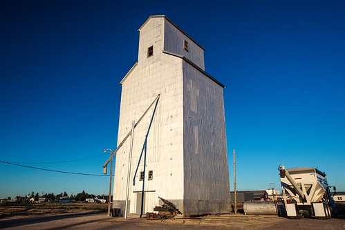 railroad blue sky sunlight west color building face metal rural silver montana day commerce mt exterior unitedstates outdoor country rail sunny front structure lookingup clear moore stop western tall agriculture chute grainelevator smalltown agricultural facing greatplains