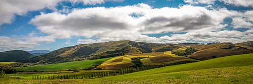 sky panorama green field grass clouds landscape outdoor farm hill hills baleage