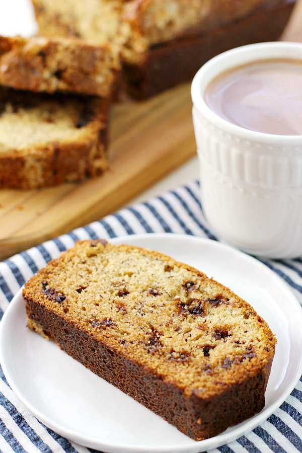 Banana Chocolate Chip Bread on a white plate with a cup of coffee.