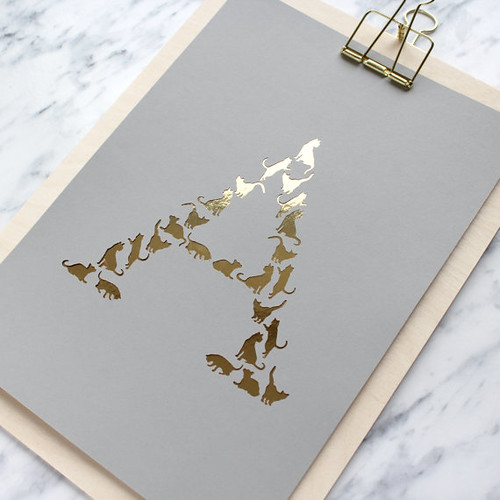 initial art (letter A) featuring tiny gold paper cut cats in grey background