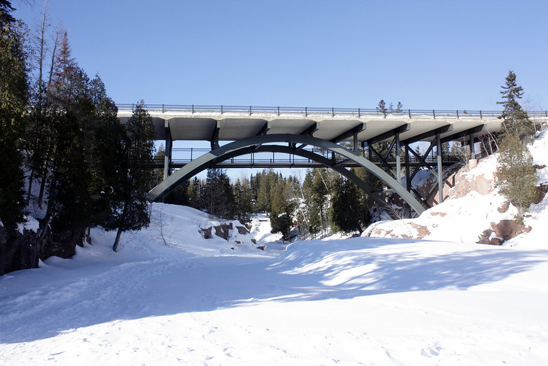 Steel arch bridge over a snow-covered river