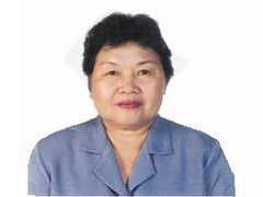 The image shows Ms. Antonia Blanca wearing light blue blouse with curly hair.