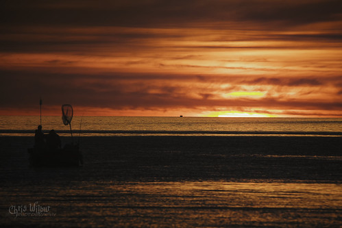 dawn sunrise dramatic sky sun silhouette moody horizon lake ontario red fish fishing people boat water