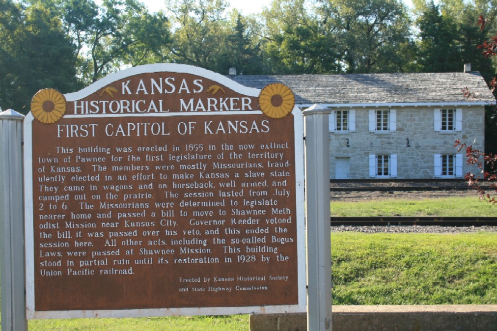 Postcard and photograph of the building which served as the first Territorial Capitol of Kansas during five days in July 1855. The building stands on the site of the former town of Pawnee, now on the grounds of Fort Riley, Kansas.