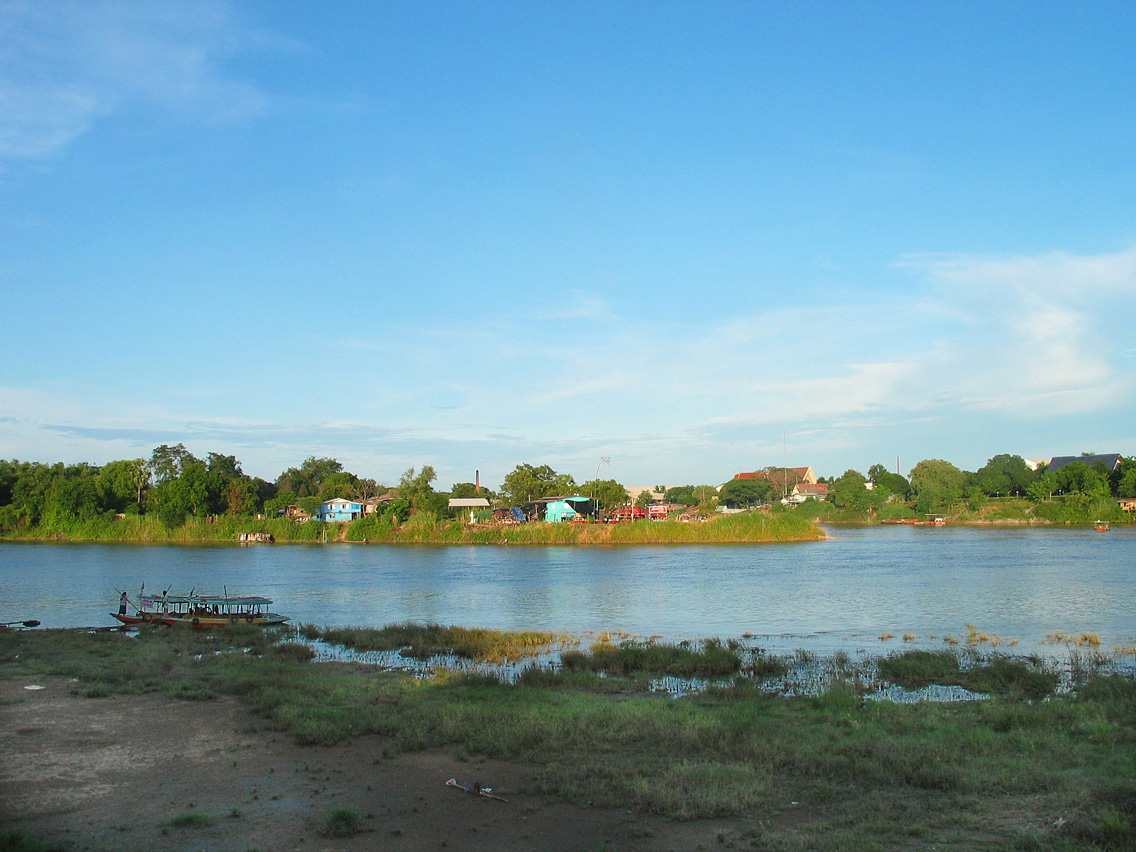 Origin of the Chao Phraya River, Nakhon Sawan, Thailand, with several small boats visible on the nearer shoreline. Photo taken in June 2003.