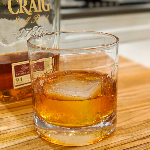 A glass of whiskey and ice cubes