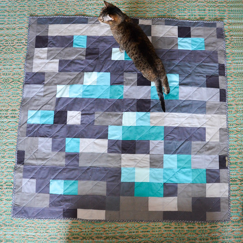 Cat enjoying the Minecraft-inspired quilt, prior to washing & drying