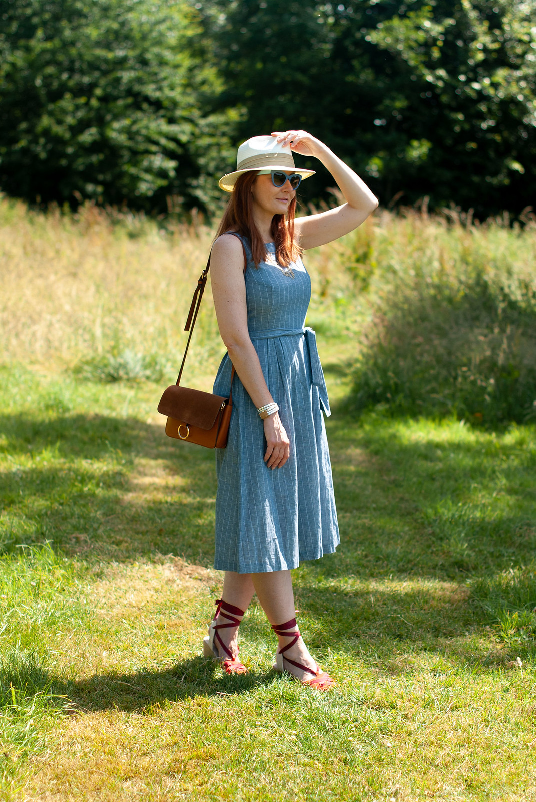 A Lightweight Chambray Dress Perfect for Summer \ styled with a cream Panama hat, tan crossbody bag, red wedge espadrilles and blue cat eye sunglasses | Not Dressed As Lamb, over 40 fashion