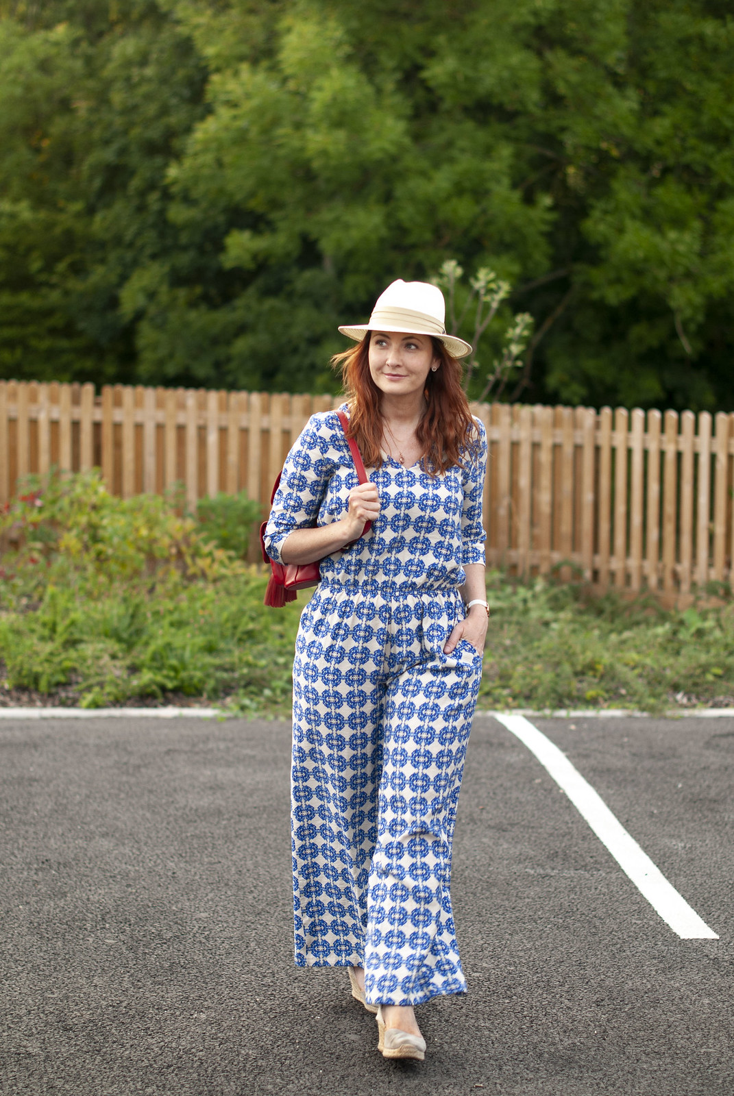 Like Nothing Else in the Shops: A Blue Patterned Jumpsuit \ grey wedge espadrilles \ cream Panama hat \ red backpack | Not Dressed As Lamb, over 40 style