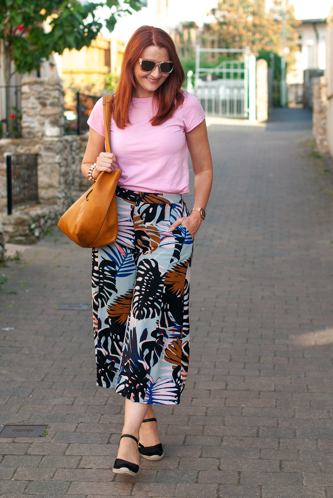 Wearing Pink With Red Hair in Summer \ candy pink t-shirt \ palm print culottes \ black wedge espadrilles \ tan hobo bag | Not Dressed As Lamb, over 40 style