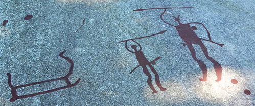 Bronze Age petroglyphs of men with spears chipped out of the granite at Tanum World Heritage Rock Art Centre in Sweden