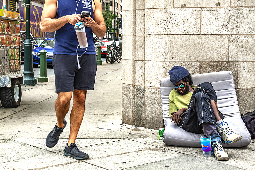 Man sitting on sidewalk at Broad and Locust--Center City