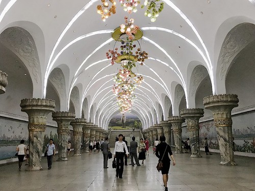 地鐵站台內天花板吊著浮誇華麗的水晶吊燈，兩側是描繪自然風光的壁畫