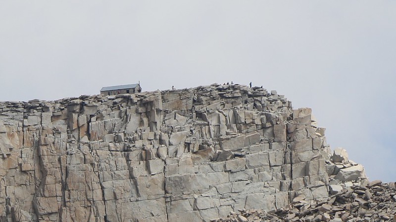 Zoomed-in view of the Whitney Summit Hut and hikers from a mile away on the John Muir Trail