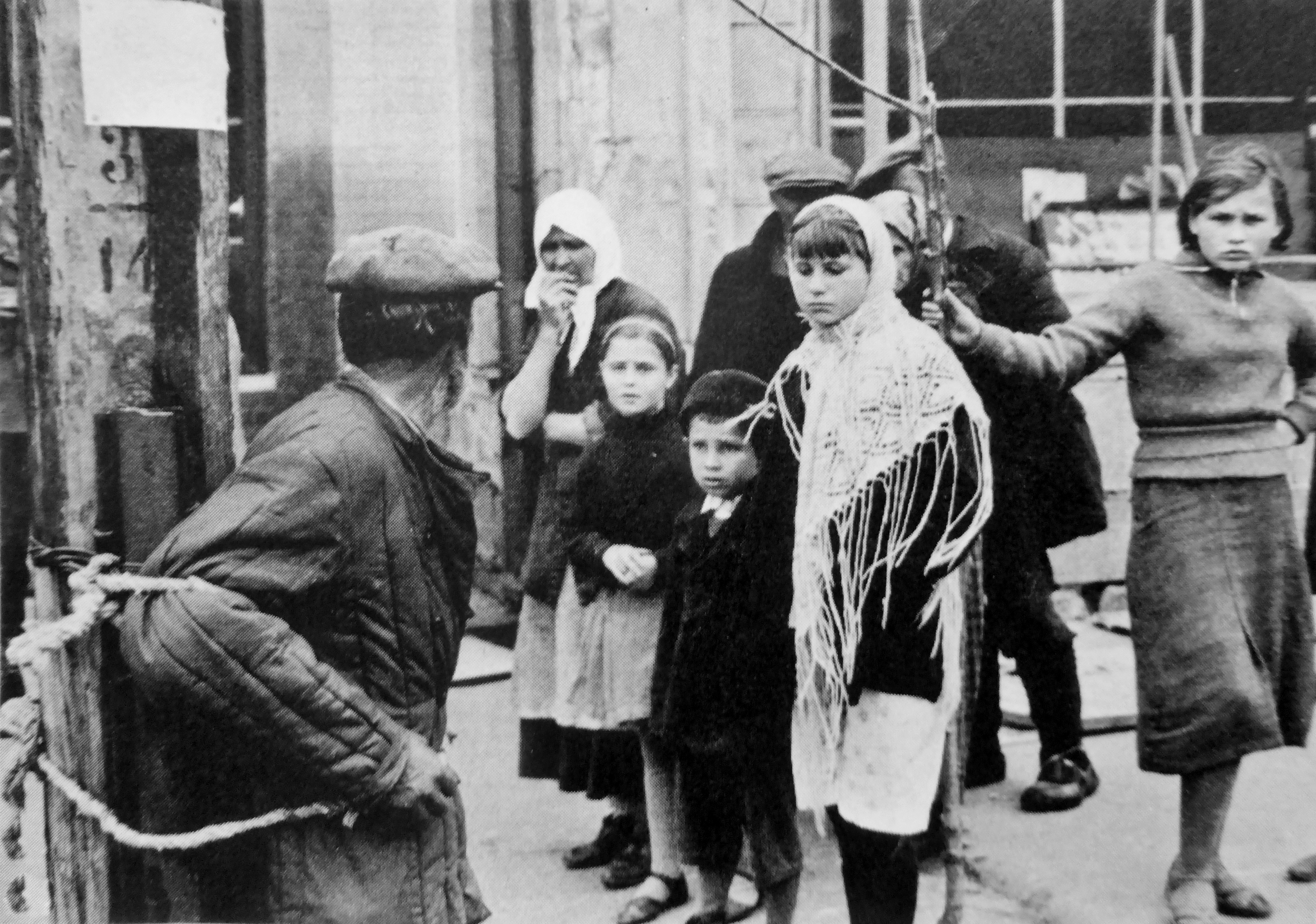 1941. Прохожие на улице оккупированного города на Украине смотрят на мужчину, привязанного немецкими солдатами к столбу