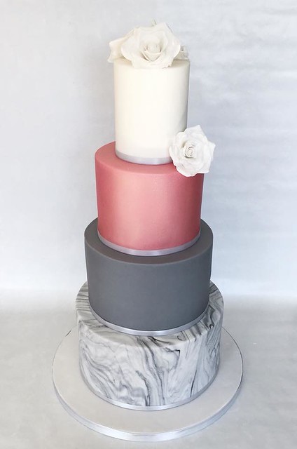 A beautiful modern 4 tier wedding cake, with handmade sugar roses, a rose gold tier and a marble tier. Designed by Velvet Frosting - Cakes by Shaunna