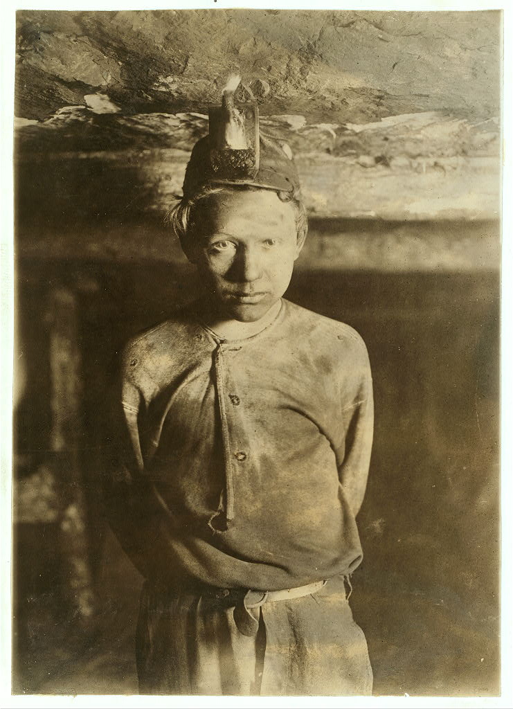 Knob Mine, Macdonald, W. Va., 1908 by Lewis Hine. The boy had to stoop on account of low roof, photo taken more than a mile inside the mine.