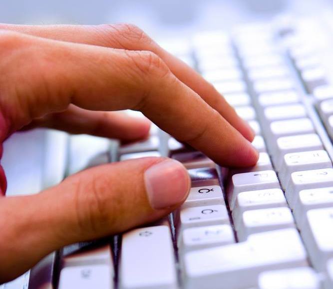 close-up of hand at computer keyboard
