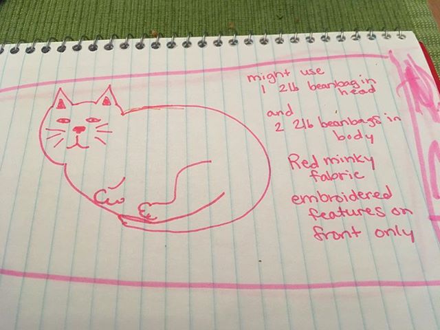 A sketch of the weighted cat-pillow that M wants me to make for her out of red minky fabric with embroidery. She thinks it would help her bother our cats less if she had a heavy, soft cat pillow she could pet on her lap whenever she wants. And she has a v