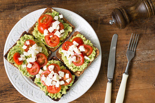 Mashed avocado, tomato and cheese toasts
